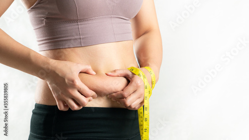Foto fat woman, fat belly, chubby, obese woman hand holding excessive belly fat with
