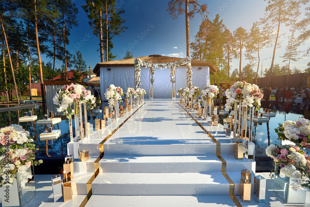 White beautiful road to the wedding arch. Decorated with flower and candle decoration