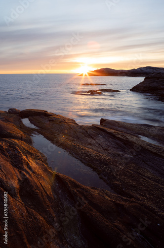 Fototapeta Naklejka Na Ścianę i Meble -  Sunset light on smoth rocs by the sea in Norway