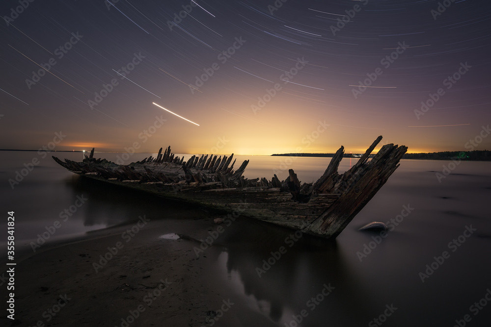Beautiful star trails with a shipwreck Raketa on the shore of Baltic Sea near Loksa, Estonia. Startrails photography.