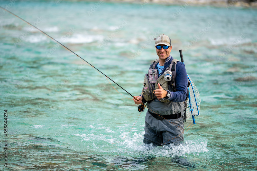 Close up of a smiled fly fisherman posing with thumb up Close up of a smiled fly fisherman posing with thumb up