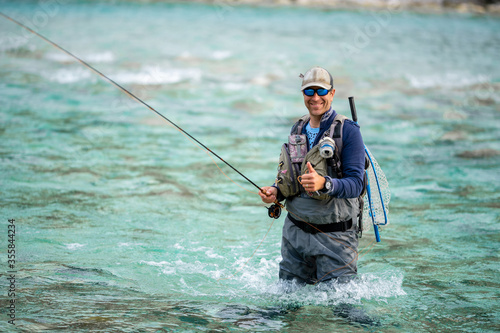 Close up of a smiled fly fisherman posing with thumb up 