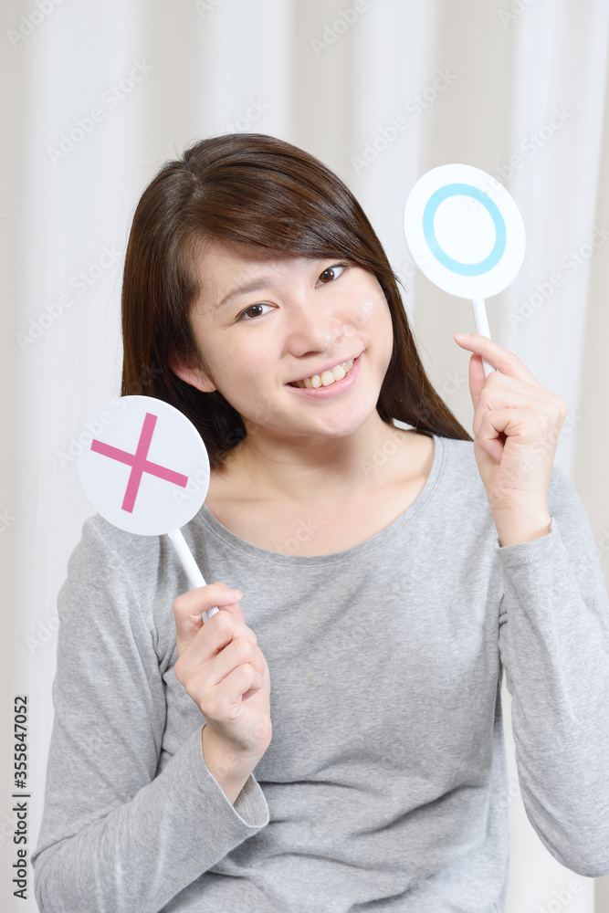 マルバツのプレートを出す女性 マルバツのプレートを出す女性