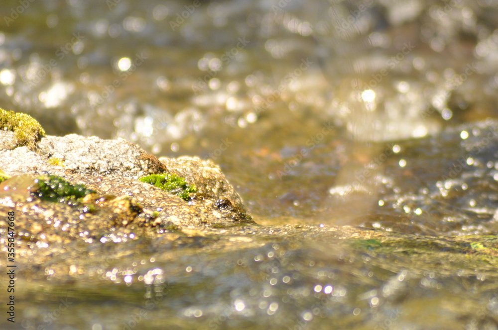 Fast flowing mountain river water in sunny spring day, macro detail Fast flowing mountain river water in sunny spring day, macro detail
