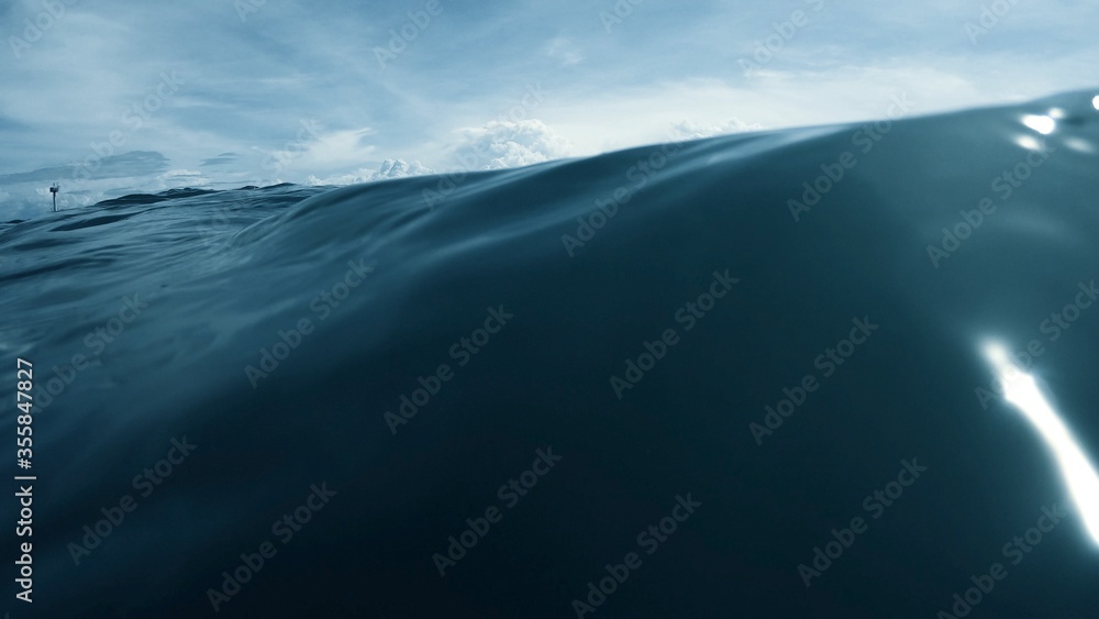 Fototapeta premium Wave on moving water surface close up in the middle of the screen. Under Water Surface in the middle of the sea