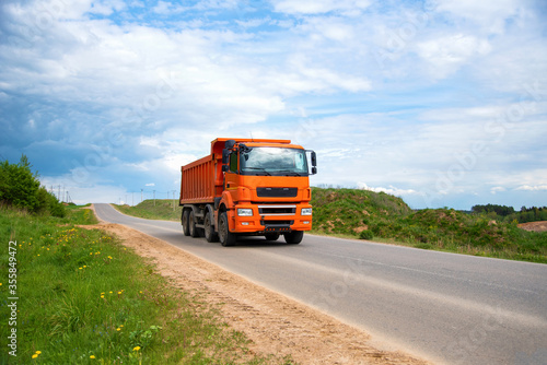 Wallpaper Mural Tipper Dump Truck transported sand from the quarry on driving along highway. Modern Heavy Duty Dump Truck with unloads goods by itself through hydraulic or mechanical lifting Torontodigital.ca