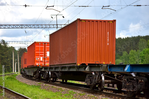 Cargo Containers Transportation On Freight Train By Railway. Intermodal Container On Train Car. Rail Freight Shipping Logistics Concept. Import - export goods from Сhina. Global economy in recession