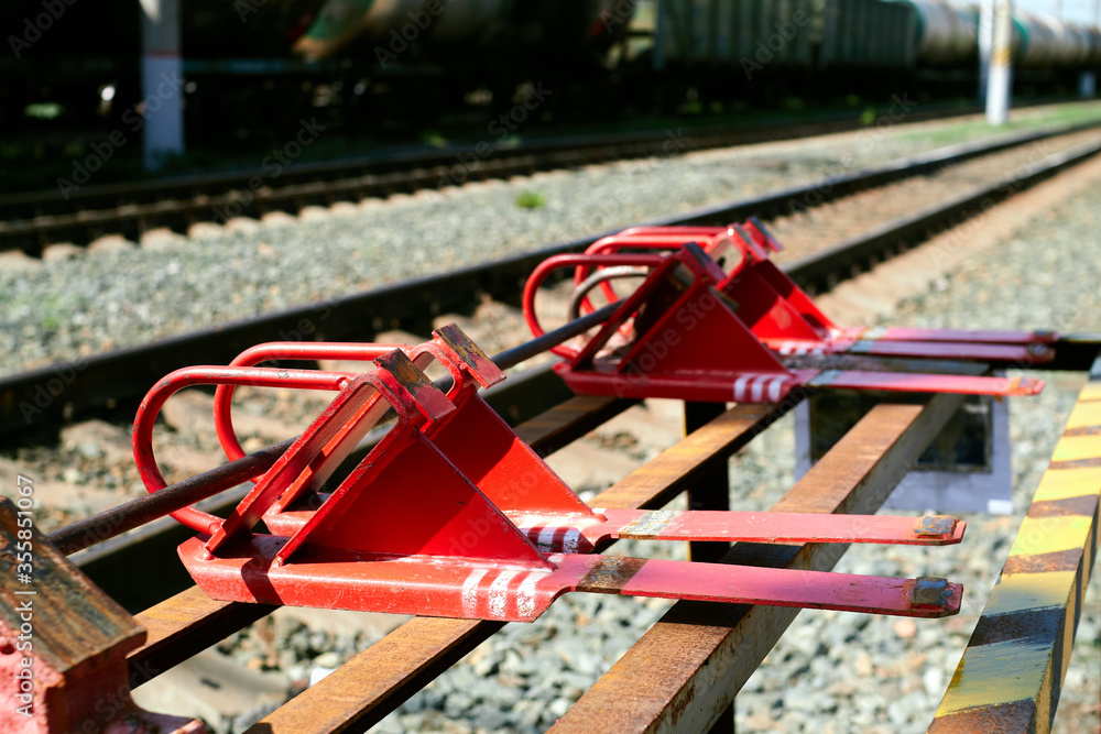 The red railway brake shoe lies on the rack.