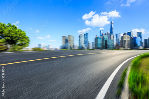 Motion blurred asphalt road and city commercial building scenery in Shanghai,China.