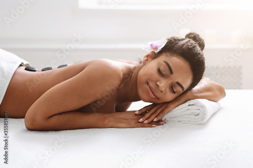 Black woman resting during hot stone massage