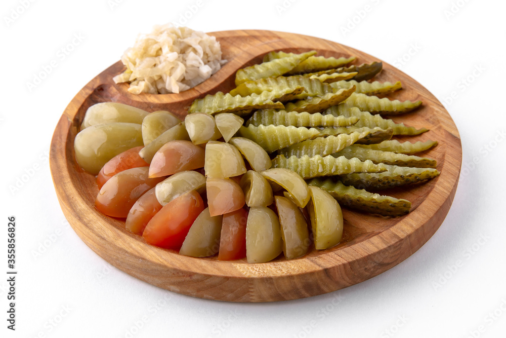 Pickles in a wooden plate. Banquet festive dishes. Gourmet restaurant menu. White background.
