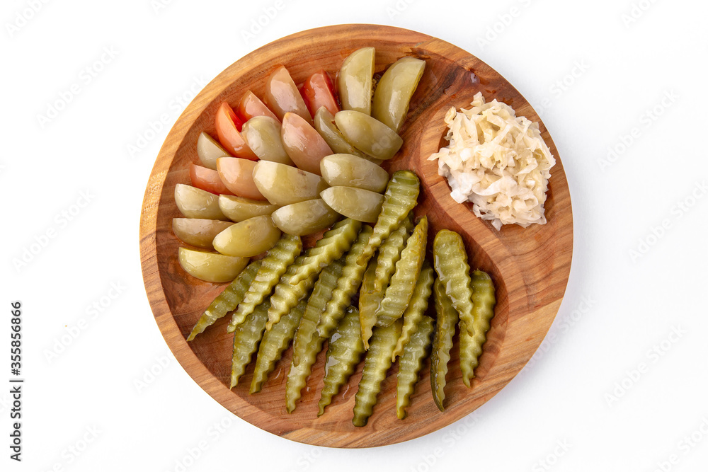 Pickles in a wooden plate. Banquet festive dishes. Gourmet restaurant menu. White background.