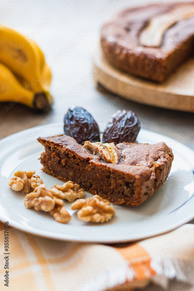View of a homemade round banana bread with bananas, dates and walnuts. View of a homemade round banana bread with bananas, dates and walnuts.