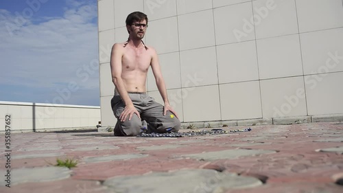 A man plays sports on the roof. A complex set of exercises based on gymnastics and karate.