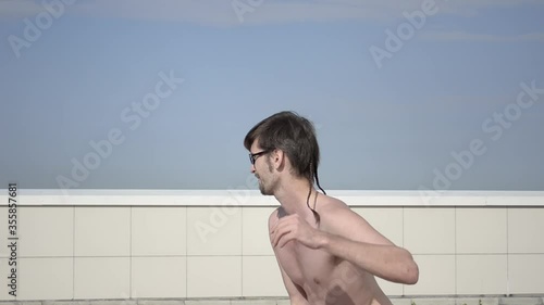 A man plays sports on the roof. A complex set of exercises based on gymnastics and karate.