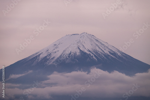 The close up of Mount Fuji in the evening. The top covered by snow and the cloud below it. 