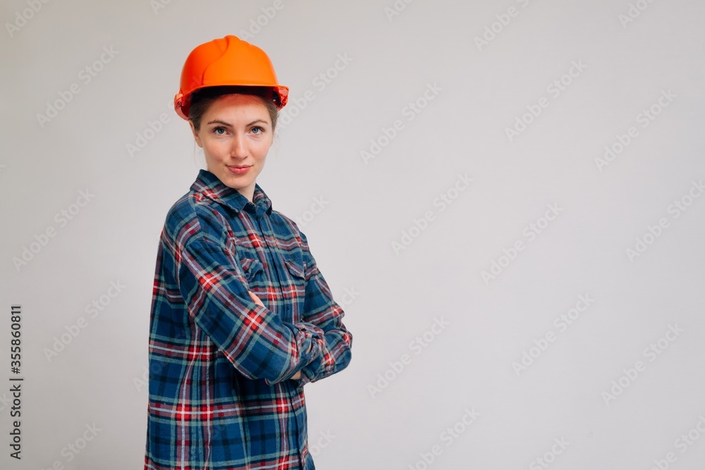 Female architect. Girl in a construction helmet looking at camera. A woman in a building uniform is smiling. Female architect. Girl in a construction helmet looking at camera. A woman in a building uniform is smiling.