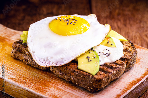 fried egg with avocado and brown bread toast.