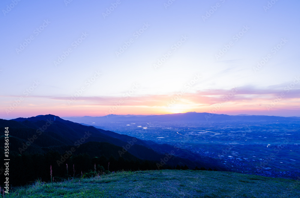 Obraz premium 山に沈む夕焼けと河と平野