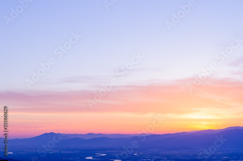 山に沈む夕焼けと河と平野