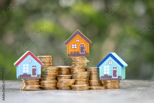 Money Financial, Business Growth,loan and real estate investment concept. house model on gold coins to stack of coins.