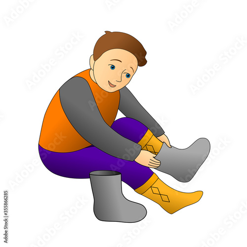 boy puts on boots, winter clothes