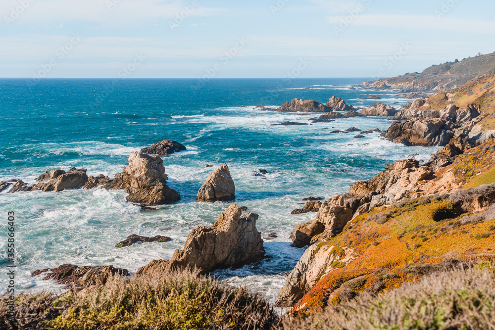 Beautiful landscape near Monterey city in California. Turquoise ocean with big waves and rocky cliffs