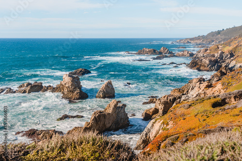 Beautiful landscape near Monterey city in California. Turquoise ocean with big waves and rocky cliffs