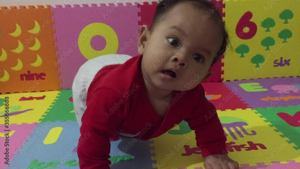Little boy playing with toys. 5-month-old baby learning how to crawl. Adorable baby crawling on puzzle mat. Happy baby crawls in the room. Baby learning how to crawl. Baby laying on floor, smiling Little boy playing with toys. 5-month-old baby learning how to crawl. Adorable baby crawling on puzzle mat. Happy baby crawls in the room. Baby learning how to crawl. Baby laying on floor, smiling