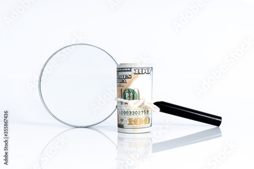 Magnifier glass and money with financial concept.
