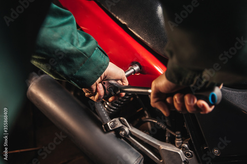Close-up male hands with wrenches. Auto mechanic works in the garage. Repair service. Motorcycle repair. 