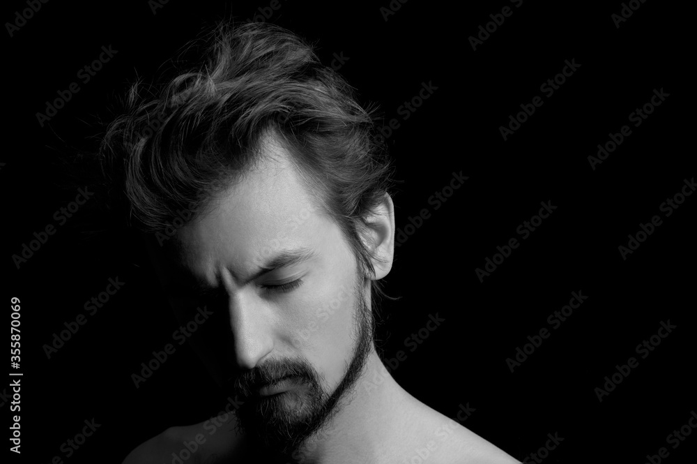 portrait of a guy with a beard and tousled hair on a black background