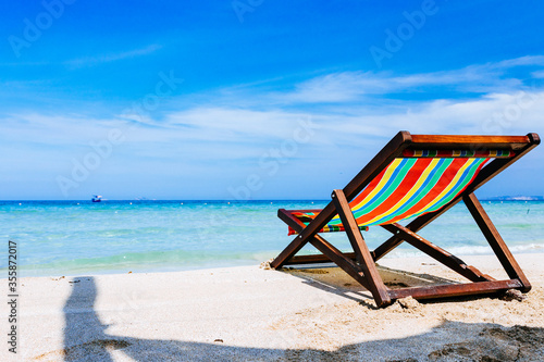 Beach chairs on a sandy beach by the ocean  the concept of relaxation  traveling on a tropical island  relaxation with beautiful views of the bruise sea and blue sky