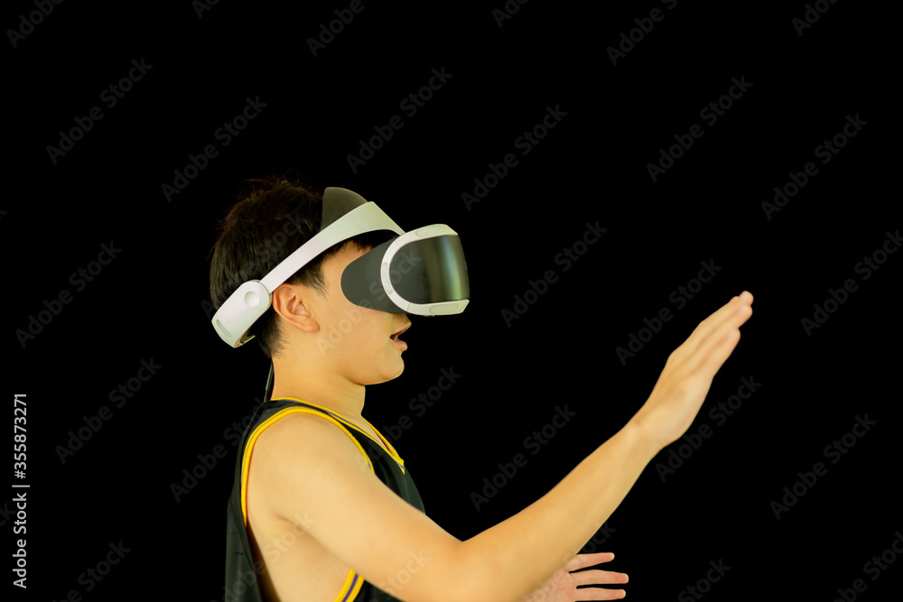 Teenager with medical mask playing game with Virtual reality headset isolated in black background. Teenager with medical mask playing game with Virtual reality headset isolated in black background.