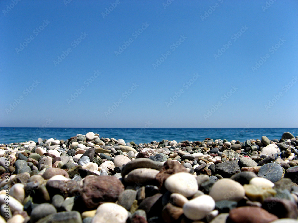 Beautiful beach landscape. Stones on the sea shore. Photo background for design and items. Summer holiday travel background. Sea and sky. Summer vacation concept Beautiful beach landscape. Stones on the sea shore. Photo background for design and items. Summer holiday travel background. Sea and sky. Summer vacation concept