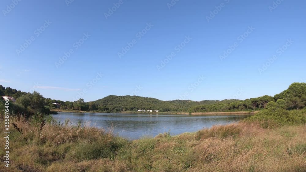 Koukounaries lake located a lagoon next to the famous Koukounaries beaches on Skiathos island, Sporades, Greece. A wooded peninsula with a stone pine forest separates the lagoon from the Aegean Sea. Koukounaries lake located a lagoon next to the famous Koukounaries beaches on Skiathos island, Sporades, Greece. A wooded peninsula with a stone pine forest separates the lagoon from the Aegean Sea.