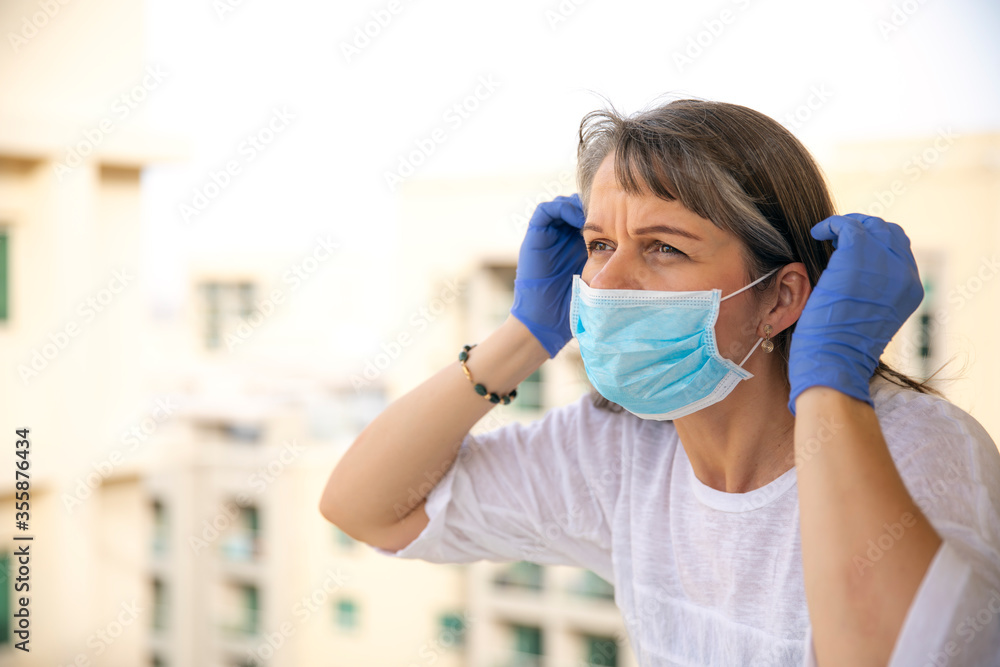 woman putting on rubber gloves during pandemic woman putting on rubber gloves during pandemic