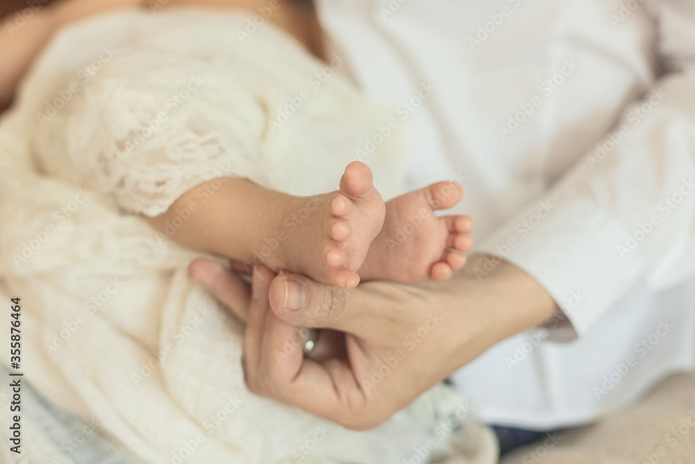 Heels of a newborn baby in the hands of a mam. Close up Heels of a newborn baby in the hands of a mam. Close up