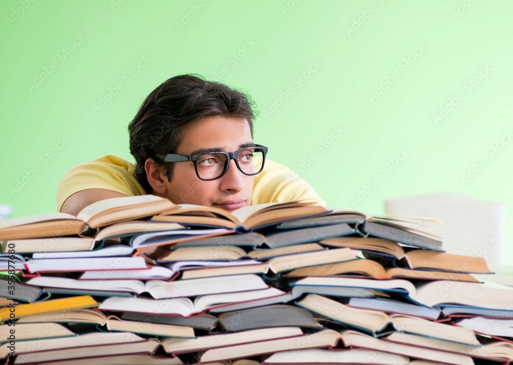 Student with too many books to read before exam Student with too many books to read before exam