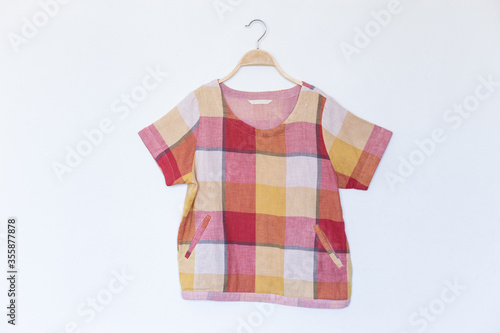 Red colour blouse is clothes hanger on white background.