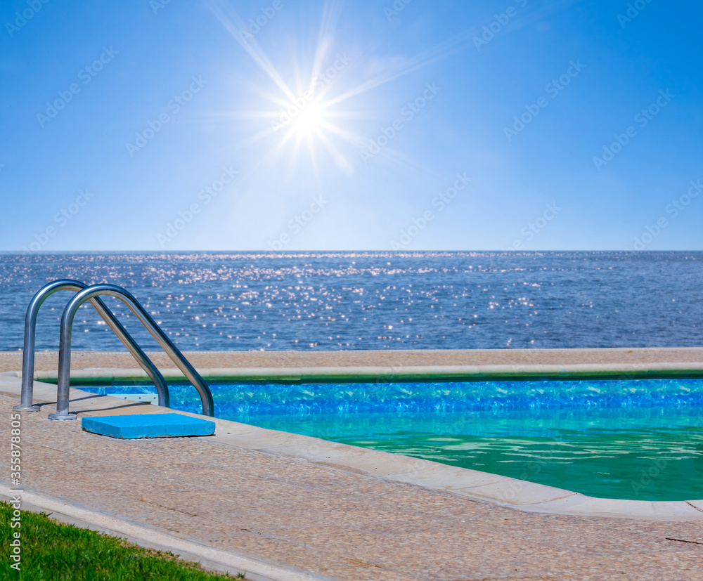 swimming pool near a sea coast under a sparkle sun