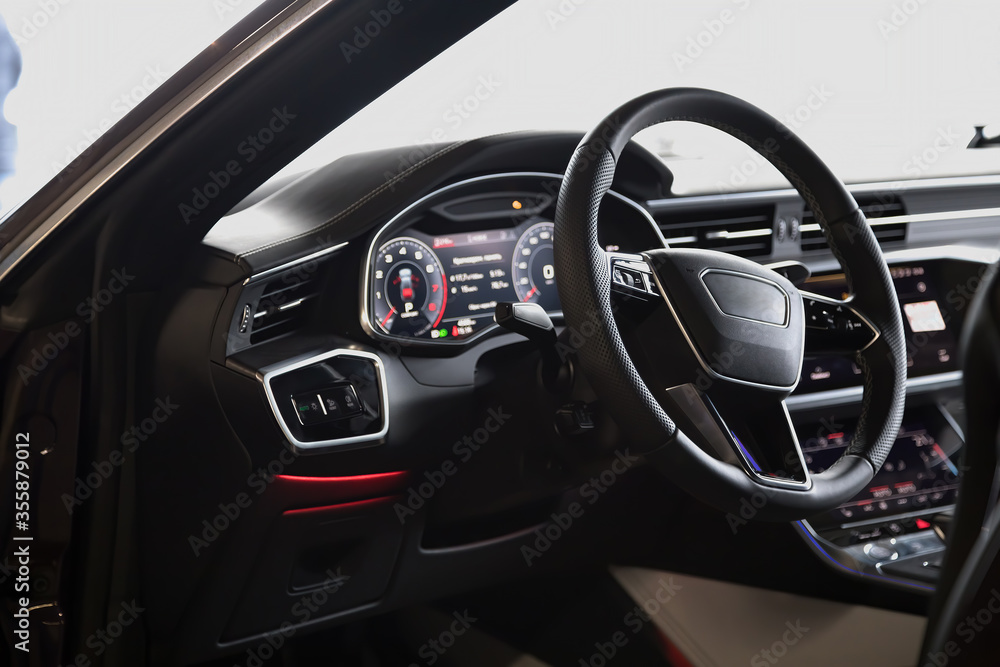 Interior of an ultra modern new luxury car. Leather chairs and wood trim, touch panels with vibration feedback and climate control. Multifunction, automatic transmission