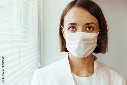 Closeup portrait of a girl doctor. Masked doctor
