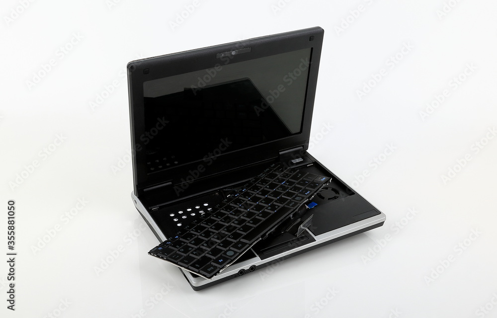 A damaged notebook keyboard and electronic parts. A damaged notebook keyboard and electronic parts.