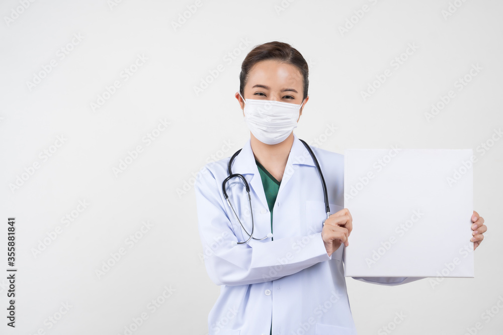 An Asian female doctor wears a surgical mask to hold a sign. Isolated white background An Asian female doctor wears a surgical mask to hold a sign. Isolated white background
