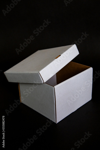 white paper box on with open lid black background. Template for your design.