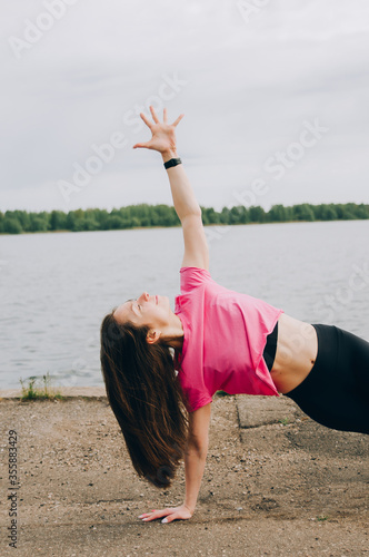 young beautiful girl athlete jogging. beautiful girl athlete is engaged in jogging. morning running. healthy sport lifestyle concept. young girl in a gray sweater and black leggings goes in for sports photo