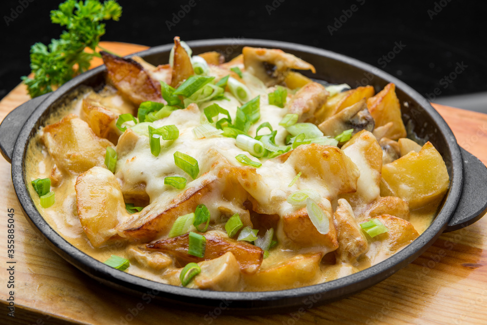 Delicious golden French fries in fast food cafe.Unhealthy,but tasty junk food.Fried potato sticks with bacon and cheese Delicious golden French fries in fast food cafe.Unhealthy,but tasty junk food.Fried potato sticks with bacon and cheese