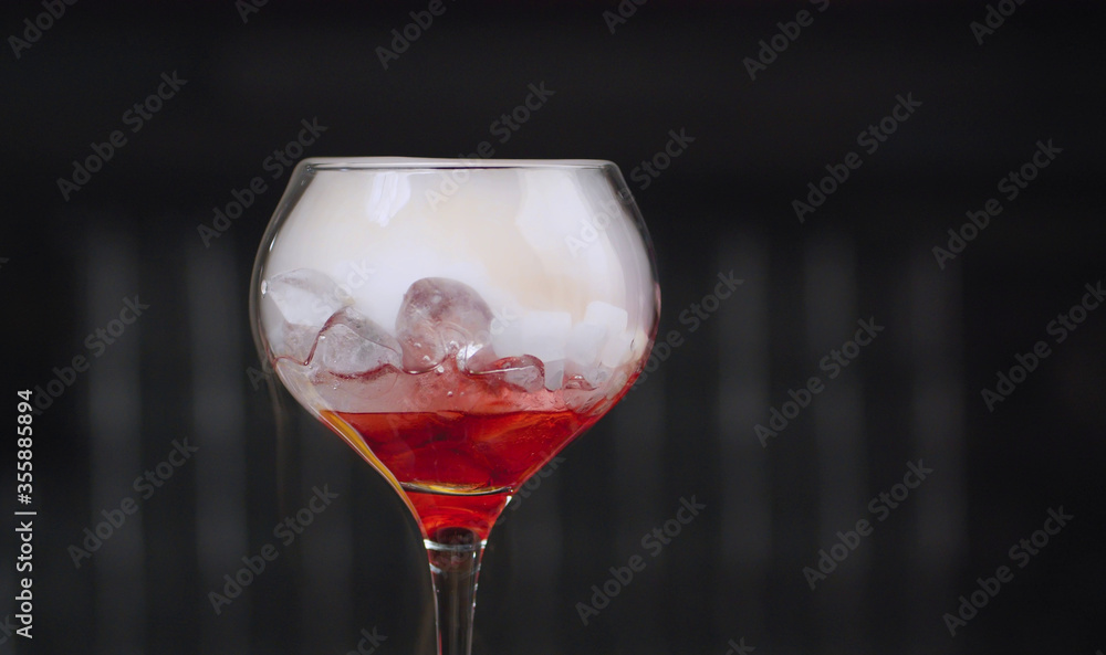 Glass of red cocktail with dry ice
