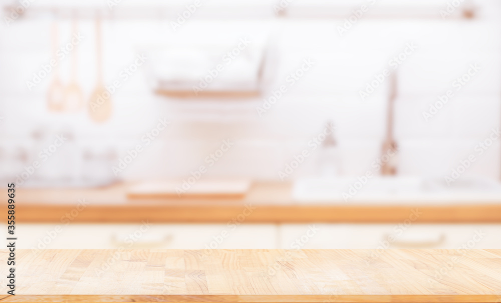 © escapejaja - Wood table top on blur kitchen room background. can be used for display or montage your products